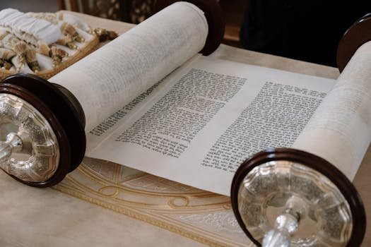 A close-up view of an open Sefer Torah on a synagogue table, highlighting intricate details.